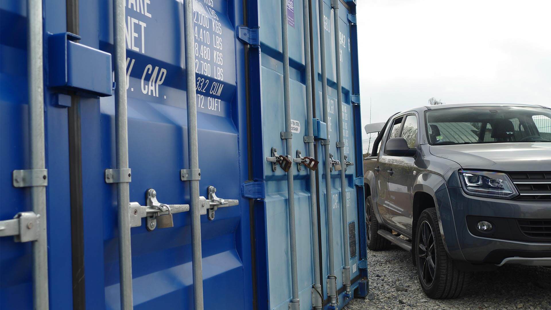 Storage container alongisde parked car.